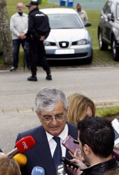 El fiscal general del Estado, Eduardo Torres Dulce realiza unas declraciones a los medios, mientras un policia nacional controla a un afectado por las preferentes, momentos antes de intervenir en la entrega de los XVI Premios Europeos de la Arquitectura Tcnica a la Seguridad en la Construccin.