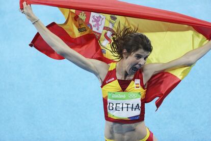 A atleta espanhola Ruth Beitia comemora com a bandeira da Espanha a medalha de ouro obtida após conseguir 1,97m em seu salto de altura na final.