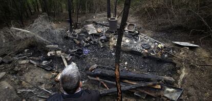 Un paseante de la Casa de Campo observa el chamizo incendiado.