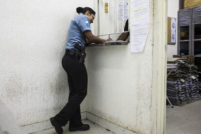 Una policía firma la recogida de su arma reglamentaria en el depósito de armas.