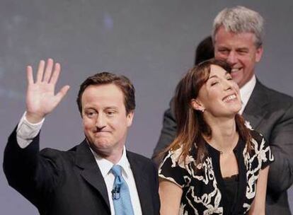 Cameron, junto a su esposa, Samantha, saluda a los delegados<i> tories</i> tras clausurar el congreso del partido.