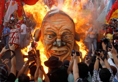 Manifestantes queman una careta que representa la cara del presidente filipino Beningo Aquino, durante la marcha del Primero de Mayo en Manila.