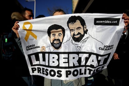 Un hombre sostiene una pancarta, con las imágenes con los expresidentes de la Asamblea Nacional Catalana Jordi Sànchez y de Òmnion Cultura Jordi Cuixart, durante la concentración contra el juicio del 'procés' en la calle Génova de Madrid.