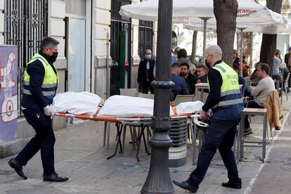 Operarios del retén fúnebre sacan el cadáver de mujer que ha sido encontrada este sábado en una vivienda de Valencia asesinada presuntamente a manos de su pareja.