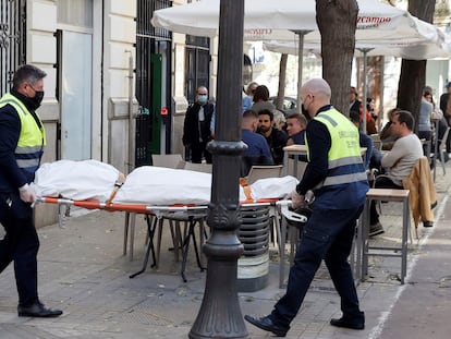 Operarios del retén fúnebre sacan el cadáver de mujer que ha sido encontrada este sábado en una vivienda de Valencia asesinada presuntamente a manos de su pareja.