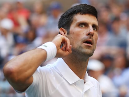 Novak Djokovic se lleva la mano a la oreja durante el partido contra Nishikori en la tercera ronda.