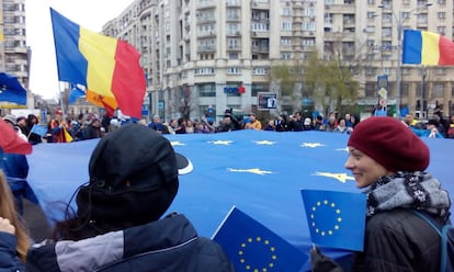 Un grupo de manifestantes rumanos porta una bandera de las doce estrellas, en febrero en Bucarest.