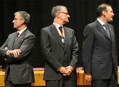Fernando Ruiz Piñeiro e Ibarretxe miran en direcciones opuestas, separados por el presidente del Colegio Notarial del País Vasco.