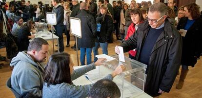 Un ciudadano deposita su voto en una urna en el colegio electoral de Sant Julià de Ramis, Girona.