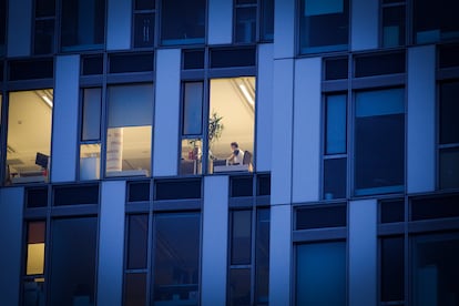 Un empleado trabaja de noche en un edificio de oficinas.