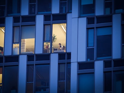 Un empleado trabaja de noche en un edificio de oficinas.