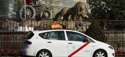 Un taxi circula por la Plaza de Cibeles de Madrid.