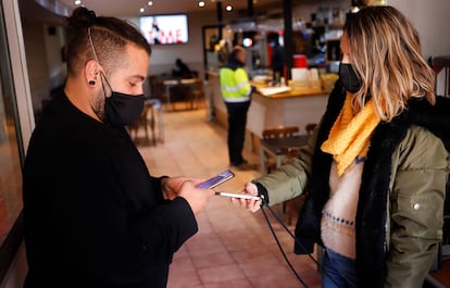 Un camarero solicita el pasaporte covid a un cliente en un restaurante de Terrassa.