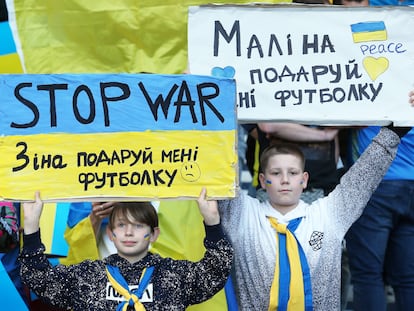 Dos niños ucranios piden la paz durante un partido de clasificación de su selección para el Mundial, el 1 de junio en Glasgow (Escocia).