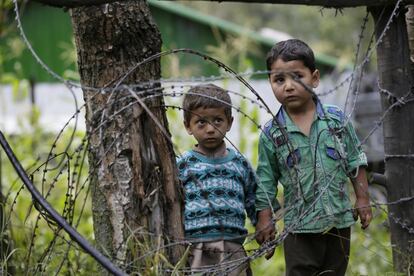 Niños de Cachemira se cogen de las manos y se acercan a la frontera que divide Cachermira entre India y Pakistán. 