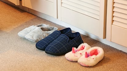 Las zapatillas colocadas a la entrada de una casa de un padre, una madre y una hija.