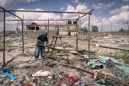 Un vecino corta madera para construirse una nueva vivienda, aun sabiendo que, probablemente, se la volverán a tirar. No había transcurrido un mes desde la primera demolición cuando unos empleados de los Servicios Metropolitanos de Nairobi llegaron para informar de que la zona donde las familias se estaban realojando también iba a servir a la nueva autovía principal y a otras áreas industriales.