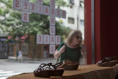 Mulher olha para vitrine em promo&ccedil;&atilde;o em S&atilde;o Paulo.