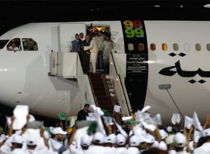 Abdelbaset Alí Mohamed Al Megrahi baja con bastón del avión en el que fue trasladado ayer a Trípoli.