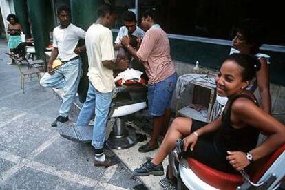 Un grupo de jóvenes hispanos, en una peluquería al aire libre en una calle de Nueva York.
El voto de esta minoría tiene cada día más peso en la ciudad, hasta el punto
de que ya casi es determinante a la hora de decidir la permanencia en el cargo de un concejal.