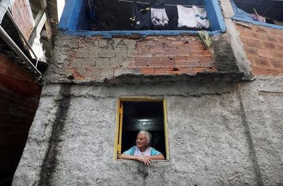 Raimunda Marcelinha dos Reis, de 93 años se sienta en la ventana delantera de su casa en Río de Janeiro, Brasil.