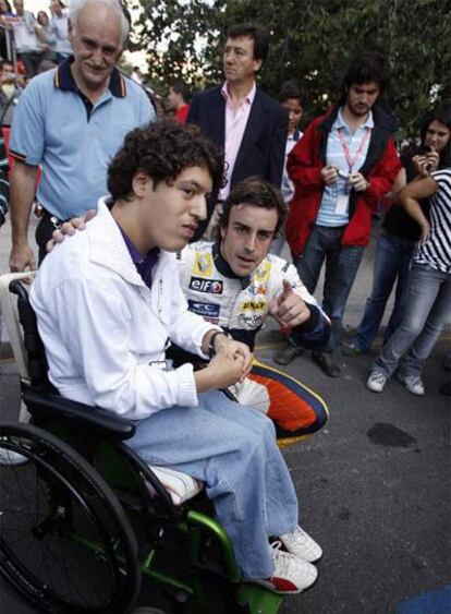 Fernando Alonso posa con un aficionado ayer en Madrid.