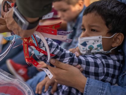 Un agente fronterizo de Texas le quita una pulsera de estado migratorio a Santiago, quien viajó junto a su madre desde Honduras para solicitar asilo.