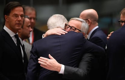 Juncker e Barnier s abraçam na cúpula de Bruxelas, neste domingo.