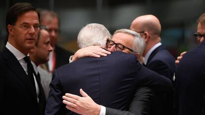 Juncker e Barnier s abraçam na cúpula de Bruxelas, neste domingo.