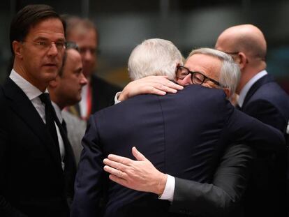 Juncker e Barnier s abraçam na cúpula de Bruxelas, neste domingo.