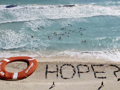 Activistas de Greenpeace demandan "esperanza" para luchar contra el cambio climático en la playa de Cancún.