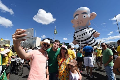 Los manifestantes cargan un muñeco de Lula con ropa de presidiario.