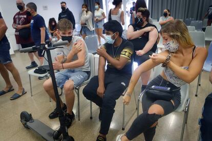 Tres jóvenes esperan tras vacunarse contra la covid-19 en Terrassa.