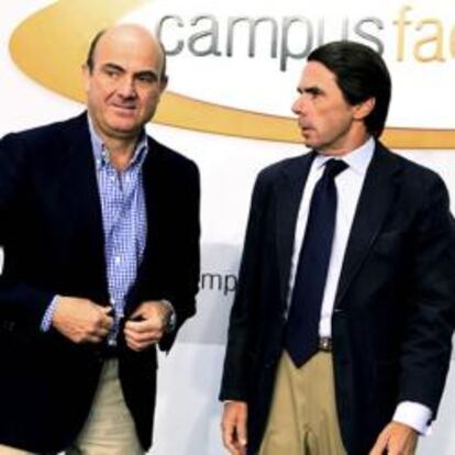 El ministro de Economía, Luis de Guindos, junto al expresidente del Gobierno, José María Aznar.