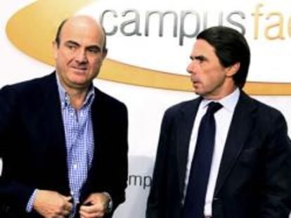 El ministro de Economía, Luis de Guindos, junto al expresidente del Gobierno, José María Aznar.