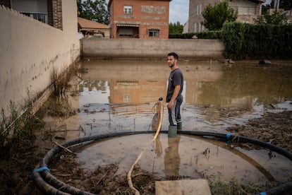 Un hombre con una bomba de achique en una parcela inundada.