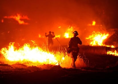 A firefighter lights a backfire as the Rocky Fire burns near Clearlake, Calif., on Monday, Aug. 3, 2015. The fire has charred more than 60,000 acres and destroyed at least 24 residences. (AP Photo/Josh Edelson)