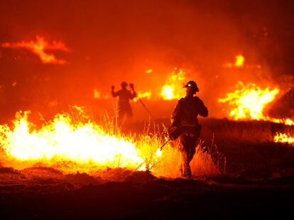 A firefighter lights a backfire as the Rocky Fire burns near Clearlake, Calif., on Monday, Aug. 3, 2015. The fire has charred more than 60,000 acres and destroyed at least 24 residences. (AP Photo/Josh Edelson)