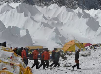 Els serveis de salvament traslladen una persona ferida a un helicòpter.