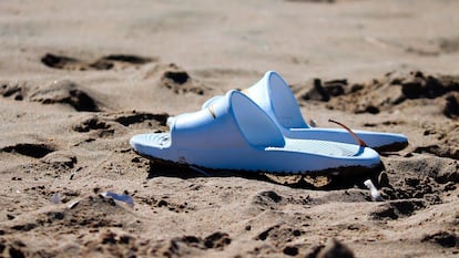 Chanclas Nike en la arena de una playa.