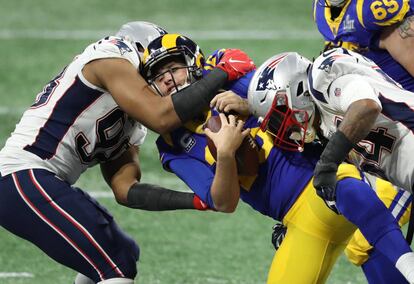 El mariscal de campo de Los Ángeles Rams, Jared Goff (16) es derribado por el ala defensiva de los New England Patriots, Trey Flowers (98) y Dont'a Hightower (54) en el transcurso del segundo cuarto del Super Bowl.