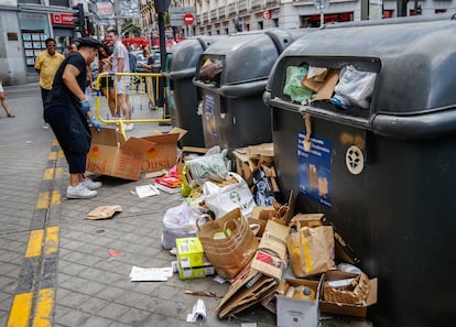 El dependiente de uno de los comercios de la Plaza de Tirso de Molina rompe las cajas para meterlas en el contenedor de reciclaje.