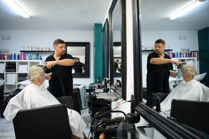 A British hairdresser working in his salon in Benalmadena, Spain.