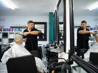 A British hairdresser working in his salon in Benalmadena, Spain. 