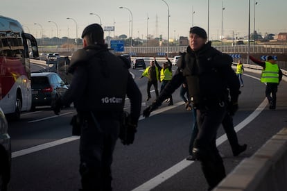 Varios agentes de la Guardia Civil intentan evitar el corte de un tramo de la A-42 a la altura de la localidad madrileña de Torrejón de la Calzada. 