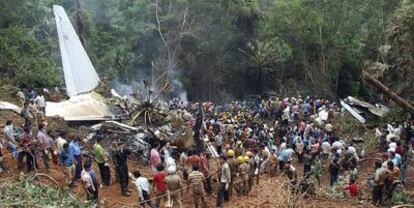 Bomberos y voluntarios trabajan entre los restos del avión siniestrado en Mangalore.