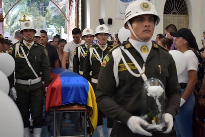 Policías colombianos cargan el féretro con los restos de uno de los siete policías muertos tras un ataque, el 6 de septiembre.