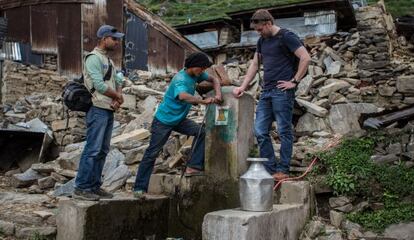 Mark Powell, especialista en agua y saneamiento de Acción contra el Hambre Nepal, revisa junto a otros compañeros y un vecino el estado y calidad de las aguas de la única fuente que ha quedado en pie.