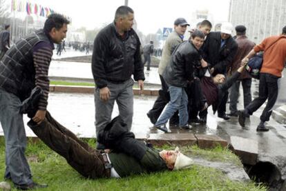 Varios hombres trasladan los cadáveres de dos manifestantes.