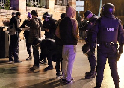 La policía cachea y toma los datos a un grupo de manifestantes en una céntrica calle de Madrid.